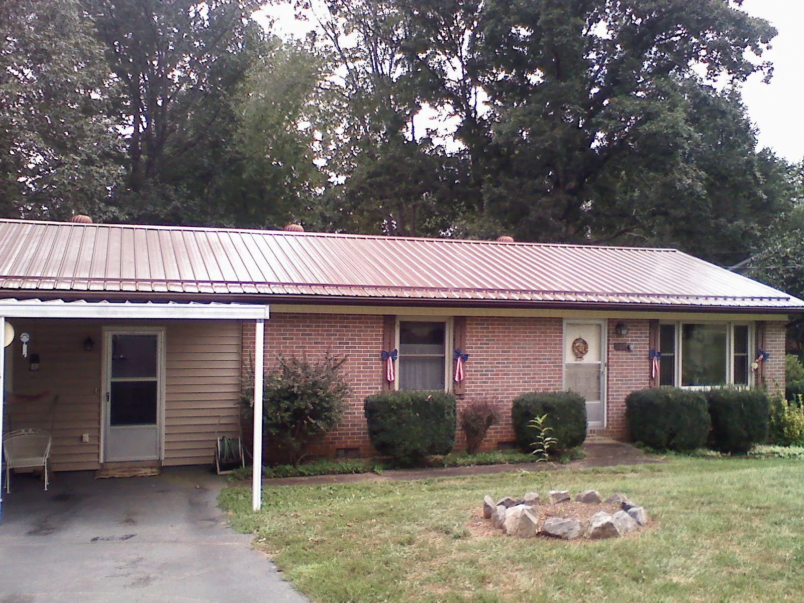 Bronze metal roof and carport on a brick ranch home — Roof Repair work by our crew in Tyler